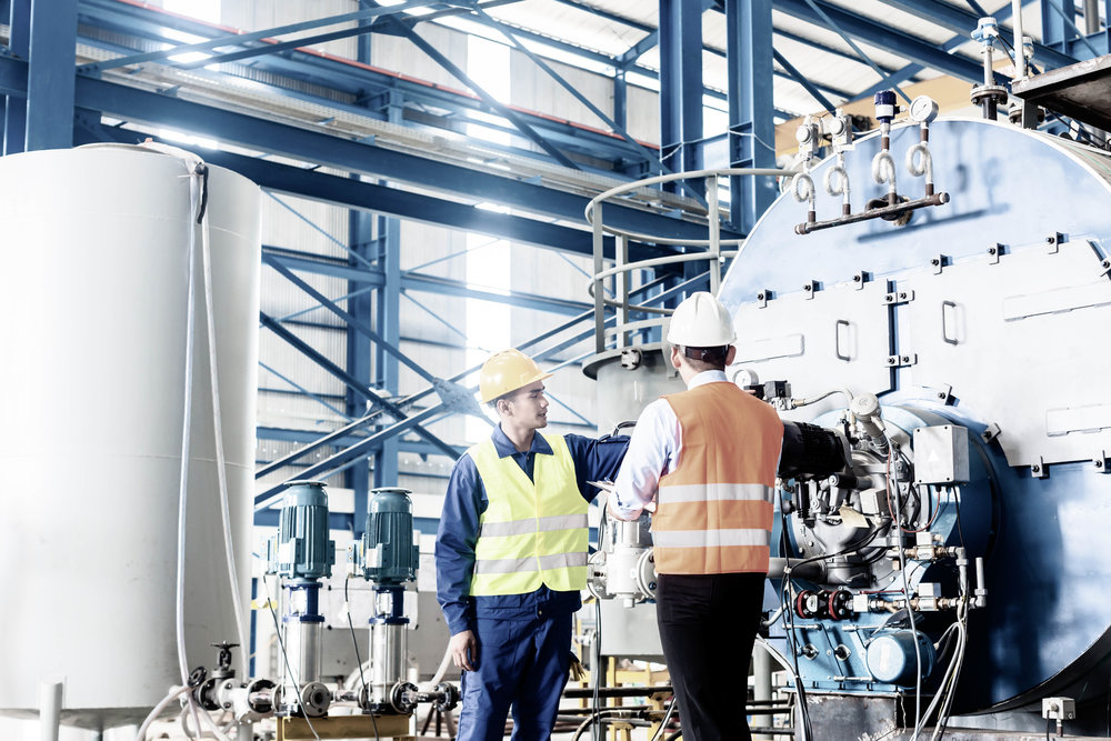 Worker and manager in industrial factory discussing acceptance of machine